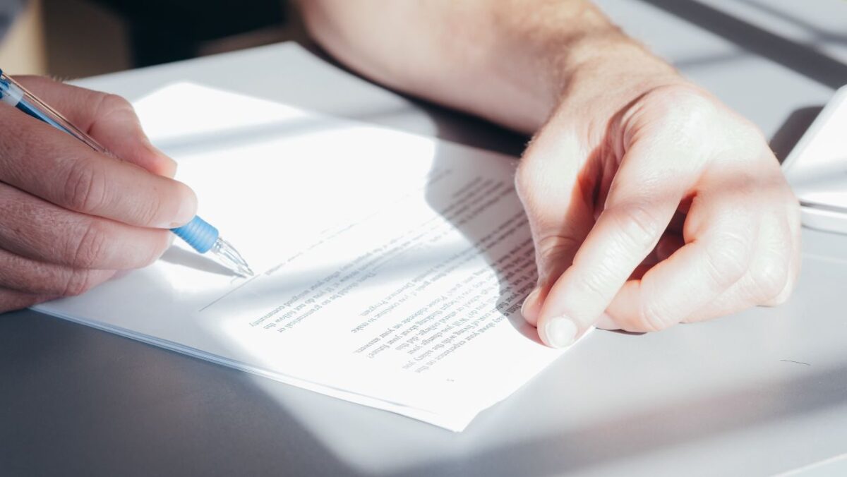 Close up of a hand signing banking documents
